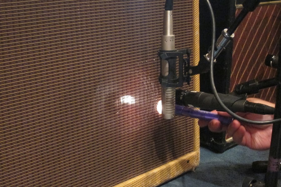 A small flashlight shining through the grille cloth to find the speaker dome